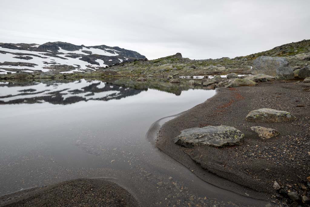 Fjellvann ved Finse med sandstrand i forgrunnen på Hardangervidda.