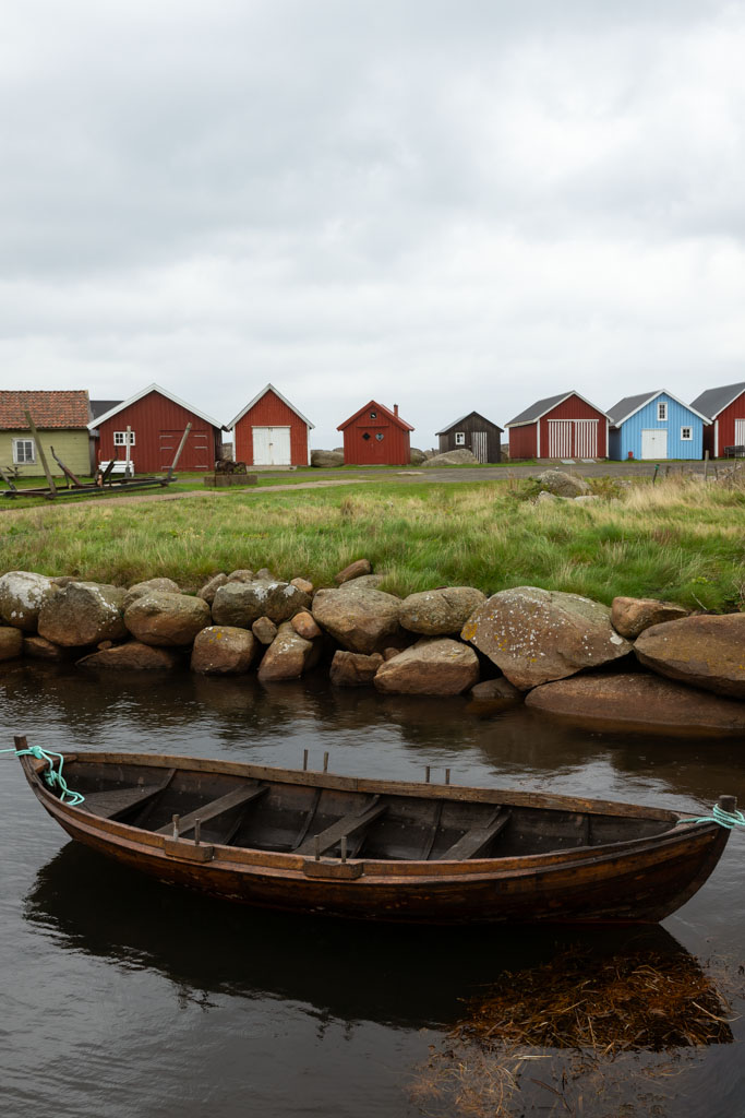 Robåt i Verevågen med fargerike naust i bakgrunnen.