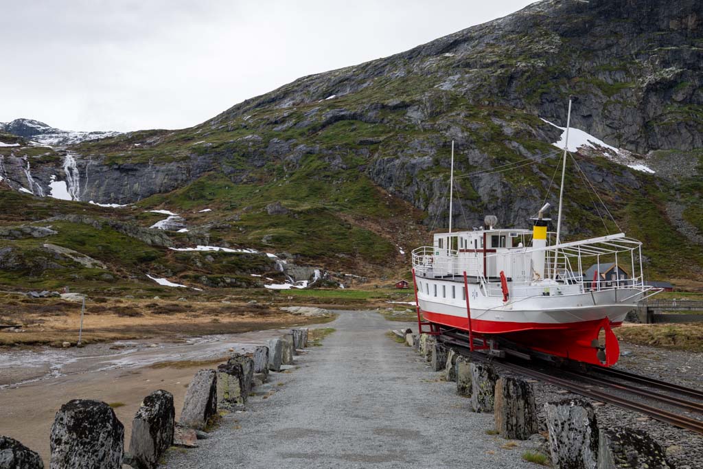 Syklister langs veien ved Bygdin med Bitihorn i bakgrunnen.
