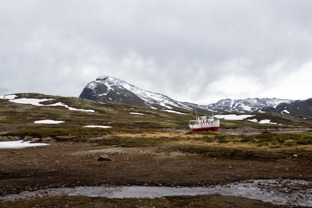 Syklister langs Bygdin med Bitihorn og fjellrekker på Valdresflye.