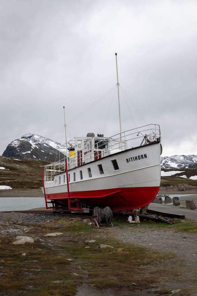 Stående utsnitt av syklister langs Bygdin med Bitihorn og fjellrekker på Valdresflye.
