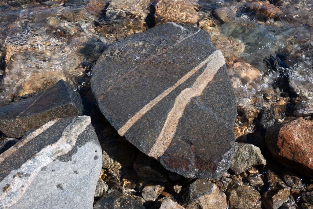 Fjellvann med steinstrand på Hardangervidda en stille sommerdag.