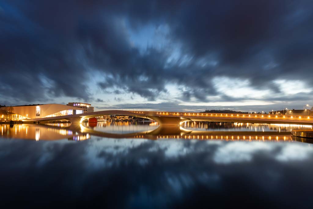 Buen kulturhus og Adolph Tidemands bro i Mandal under en dramatisk himmel, desember 2019.